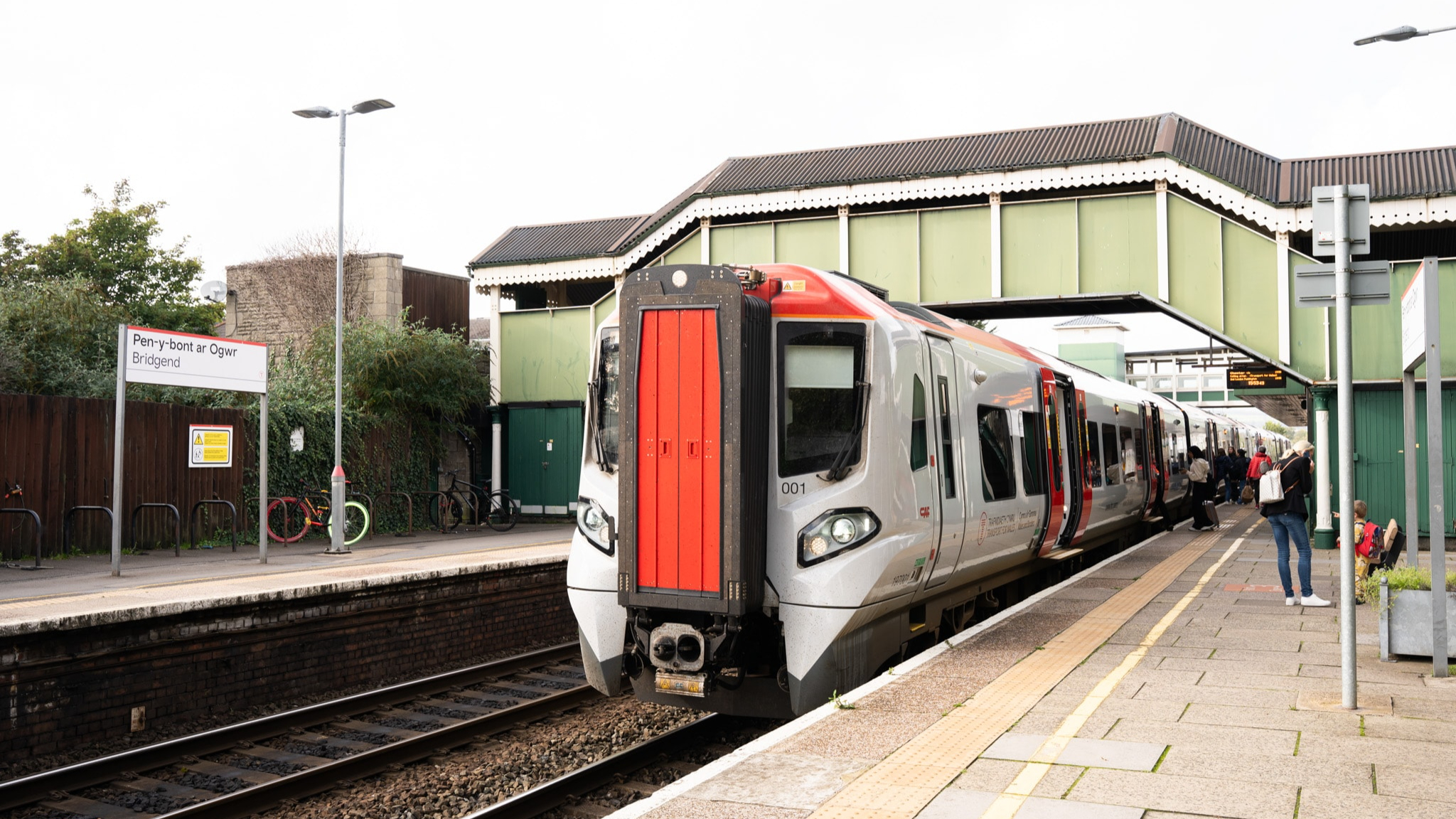 Rail engineers in orange high-visibility clothing replacing track on a closed railway line