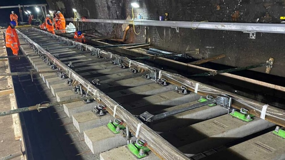 Rail engineers working on track inside a railway tunnel