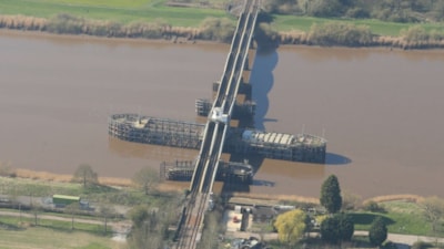 A railway swing bridge spanning a river, with the structure pivoted to allow trains to cross