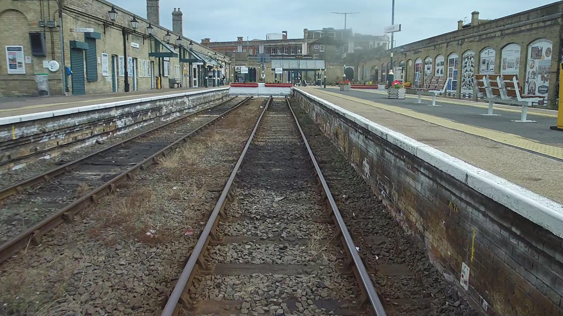Engineers renewing railway track and ballast in a station platform