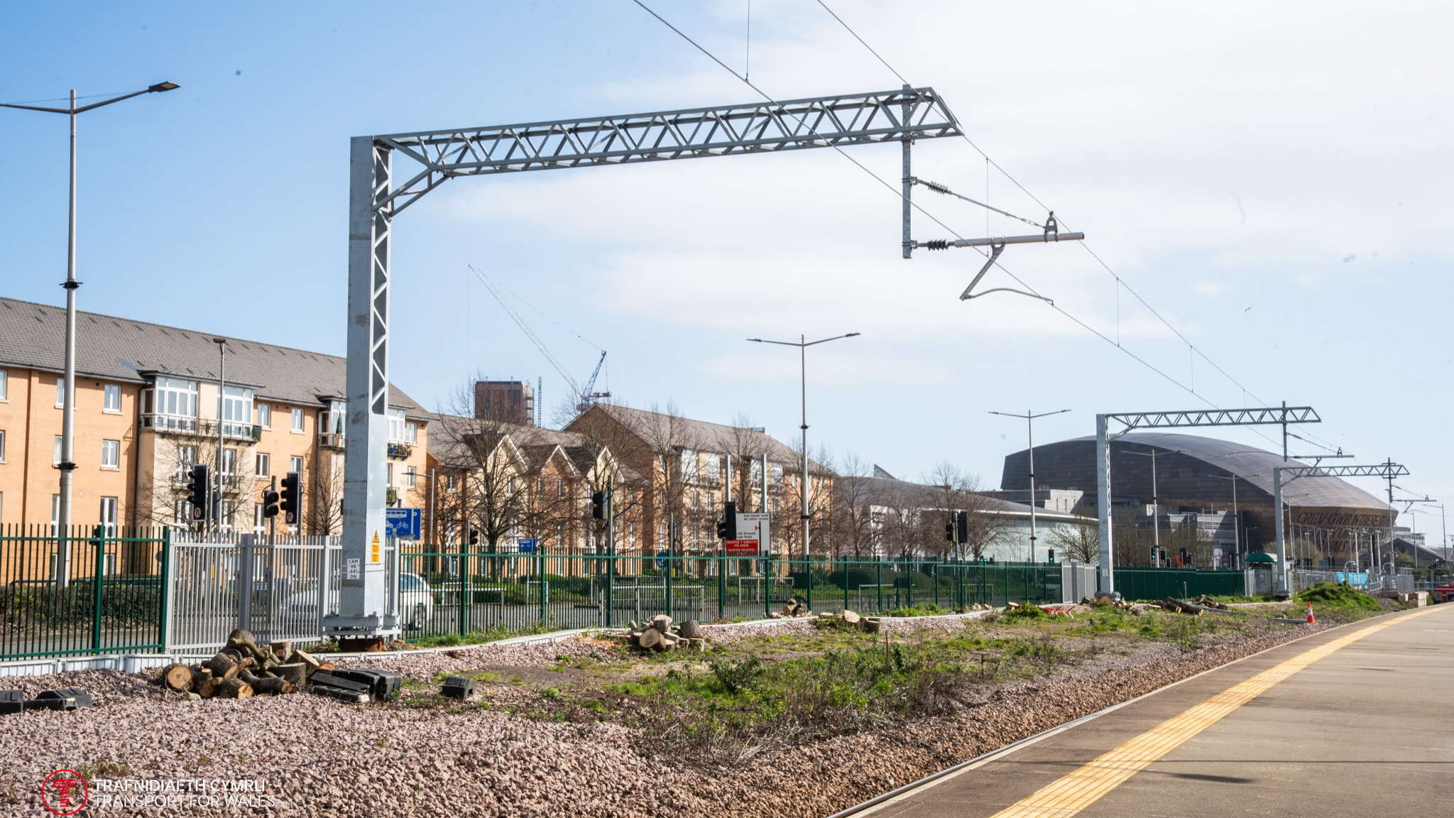 Engineers laying new railway track beneath overhead line equipment on an electrified urban line
